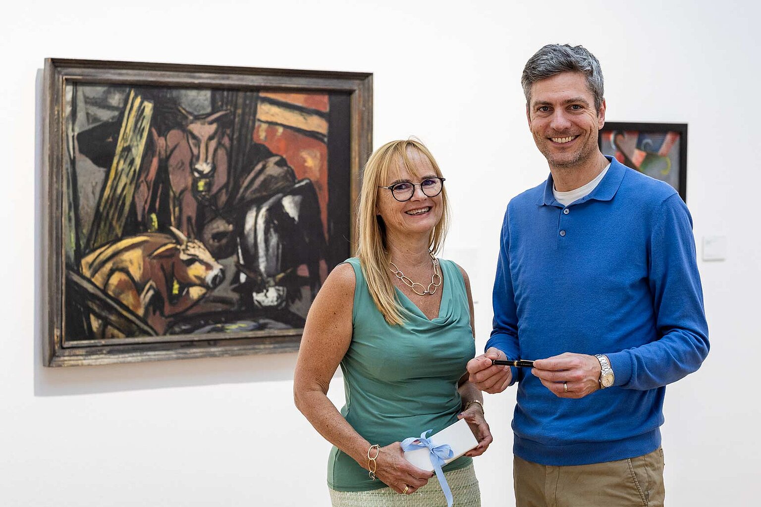 DJV Hessen „Feder für die Pressefreiheit“ 2025 Initiatorin Dr. Gabriela Blumschein-Grossmayer mit Schirmherr Ingo Zamperoni vor dem Gemälde "Ochsenstall (Vieh im Pferch)" von Max Beckmann (1884 - 1950). – DJV Hessen widmet „Feder für die Pressefreiheit“ Rukhshona Khakimova. Initiatorin Dr. Gabriela Blumschein-Grossmayer mit Schirmherr Ingo Zamperoni, in seiner Hand hält er die Feder. Im Hintergrund "Ochsenstall (Vieh im Pferch)" von Max Beckmann (1884 - 1950) im Museum Weisbaden - Hessisches Landesmuseum für Kunst und Kultur.