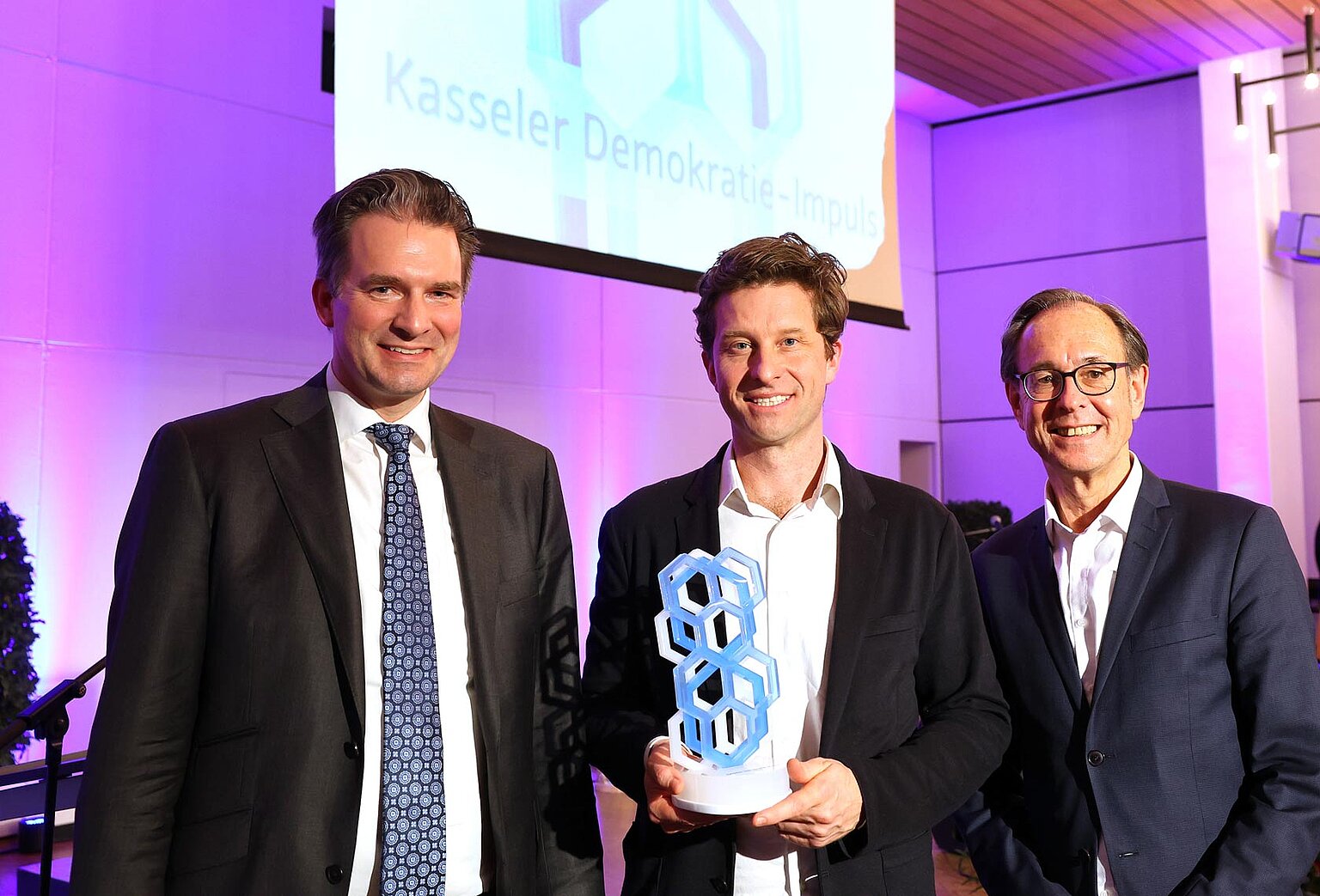 Correctiv-Chefredakteur Justus von Daniels (Mitte) mit Kassels Oberbürgermeister Sven Schoeller (links) und Demokratie-Forscher Andreas Zick. – Kasseler Demokratie-Impuls 2024 für Correctiv: Oberbürgermeister Sven Schoeller (links) überreicht den mit 3.000 Euro dotierten Preis an Chefredakteur Justus von Daniels (Mitte) für die investigative Recherche “Geheimplan gegen Deutschland”. Rechts: Laudator Prof. Dr. Andreas Zick, Demokratie-Forscher der Universität Bielefeld.